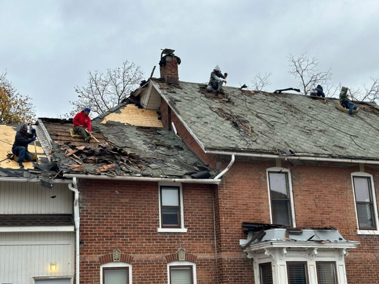 Certa Roofing team demolishing worn roof on historic home