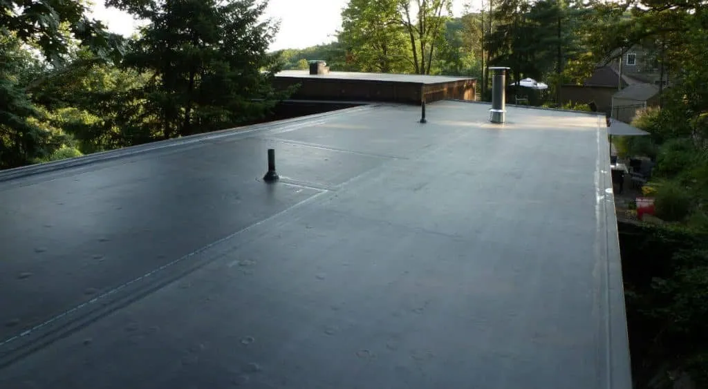 Certa Roofing black EPDM membrane roof surrounded by trees