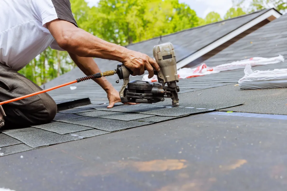 Professional roofer applying shingle roofing on residential home